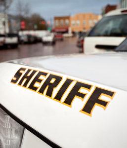 Large print of the words "Sheriff" on the side of a police vehicle